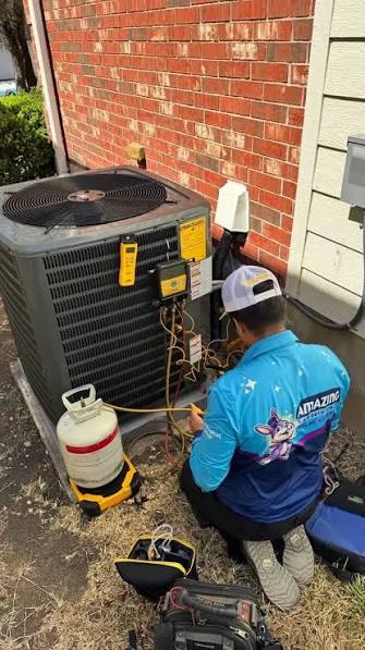Technician checking an outdoor HVAC system with service gauges